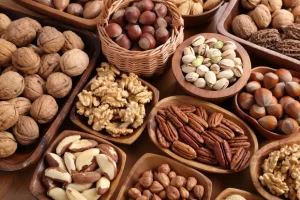 אגוזים טריים מסוגים שונים מונחים בקעריות עץ על שולחן